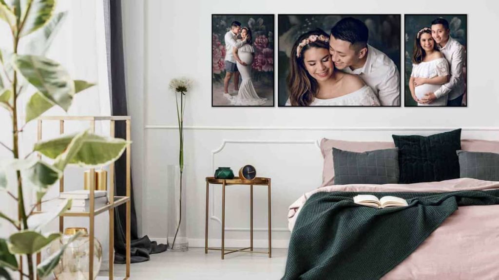 A modern bedroom scene showing 3 pieces of maternity photography wall art featuring a mum in a flowing white dress with her partner. 